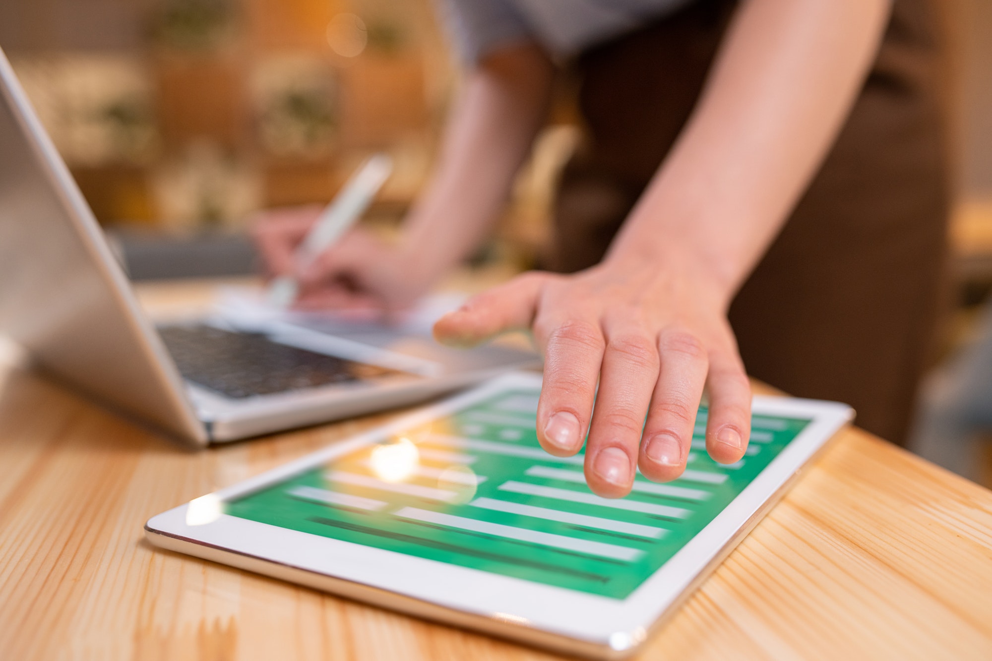 Hand of young contemporary businesswoman over digital tablet