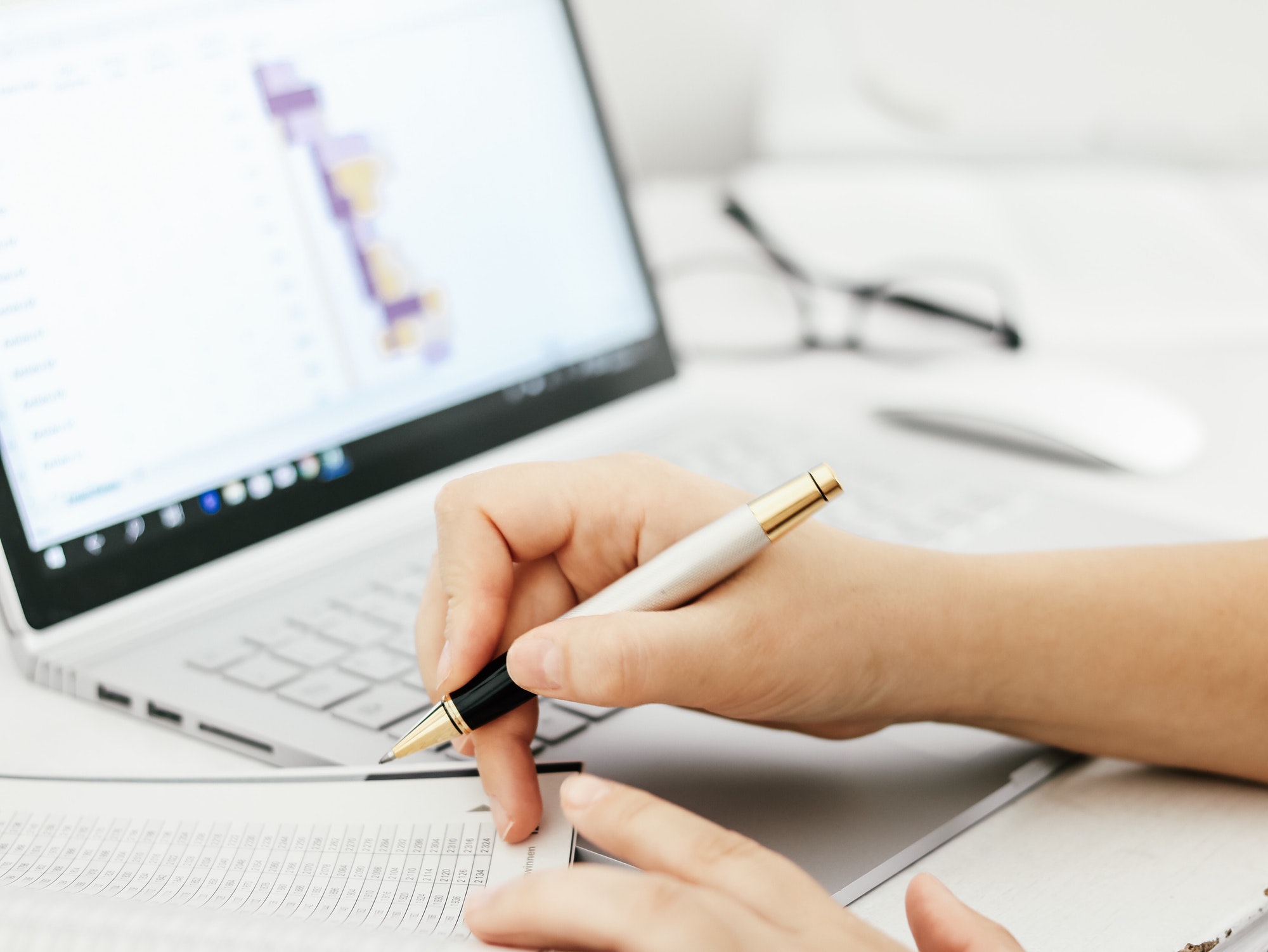 Hand with a pen. Finances. Laptop. Office work. Payroll
