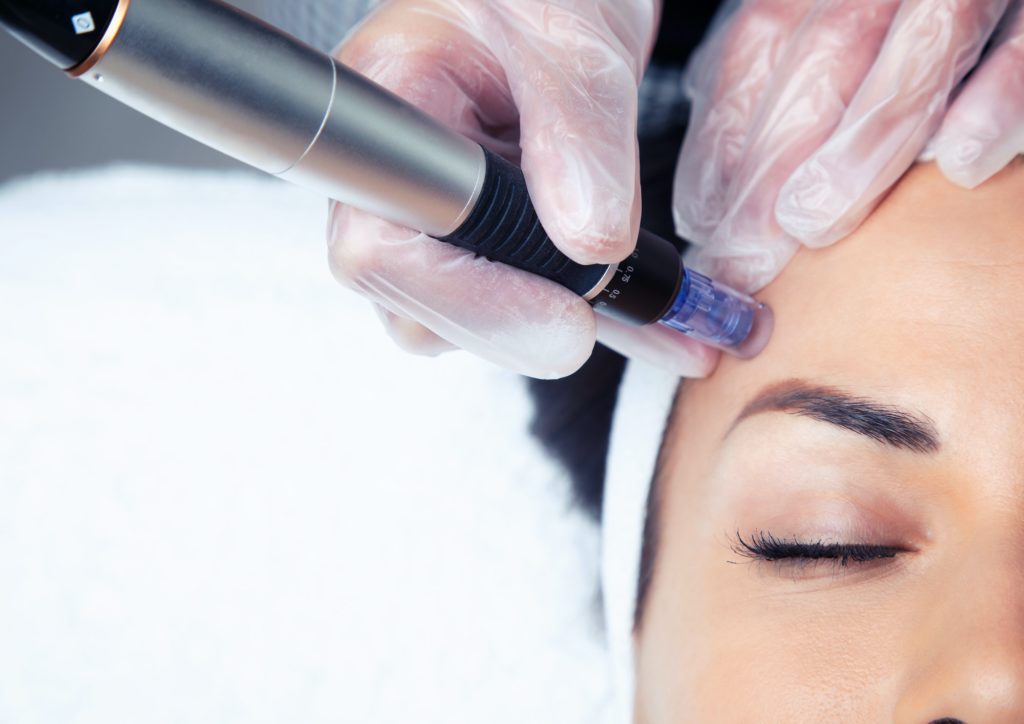 Cosmetologist making mesotherapy injection with dermapen on face for rejuvenation on the spa center.